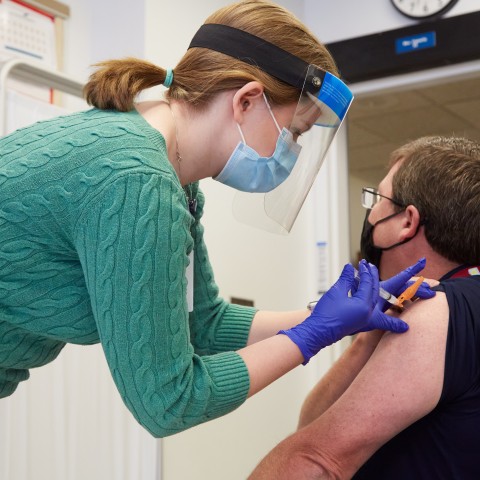 UNE COM student Emily Cathey administers a Moderna COVID-19 vaccine at Maine Medical Center in Portland