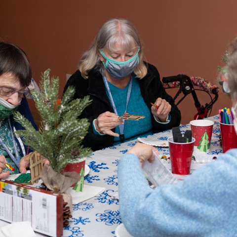 People paint holiday-themed crafts at a wellness fair for Westbrook Housing residents