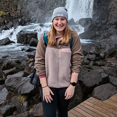 U N E student Megan Hanks stands in front of a waterfall
