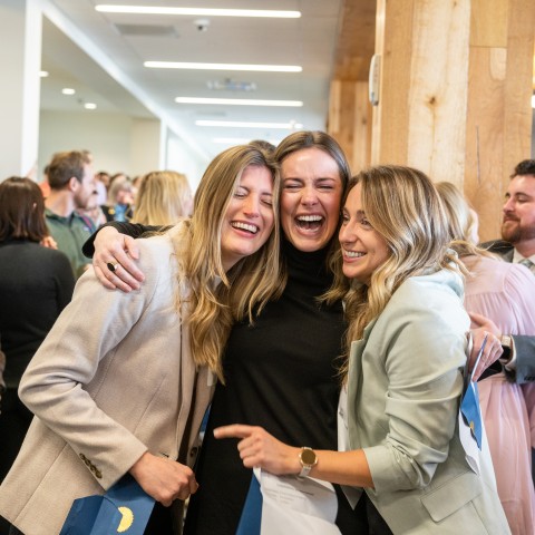 Three female students hug after learning their residency matches