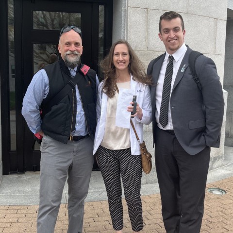 Three representatives from UNE pose outside the Maine State House. They are Ed Cervone, Bethany Miles, and Austin Vaughan..