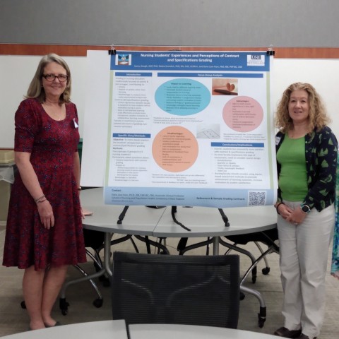 Three UNE faculty members stand next to a research poster