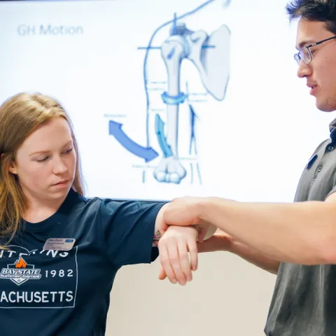 A P T student practices arm exercises on another student