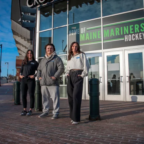 UNE students pose in front of the Cross Insurance Arena in Portland
