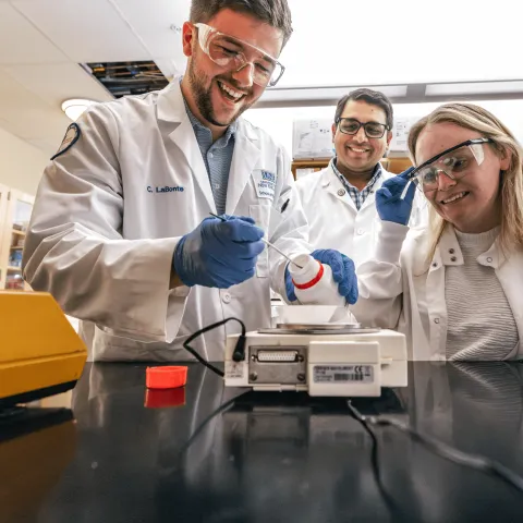 UNE faculty member Sri Mohan works with students in his lab