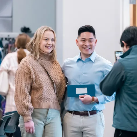 Two students pose for a photo holding a Match Day envelope