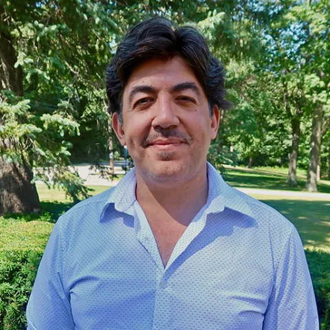 Moustafa Abu El Fadl smiles outside on a sunny day