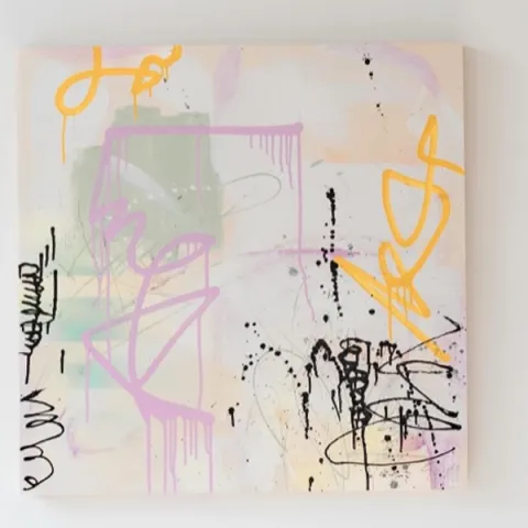 An abstract painting in pastel colors against a white wall