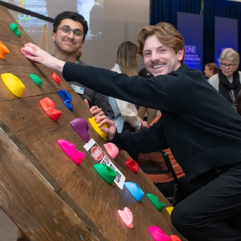 Students demonstrate their custom-made adaptive climbing wall