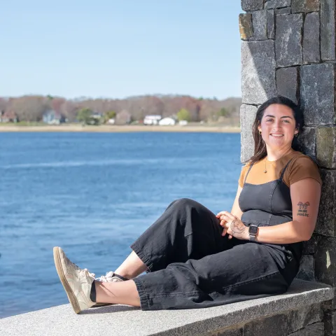 Morgan Bassett sits at Jordan's Point on UNE's campus