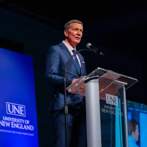 UNE President James Herbert speaks at the podium at the 2025 Fall Assembly