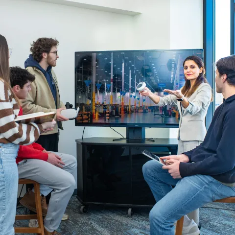 Faculty and students interact with virtual reality and discuss supply chain
