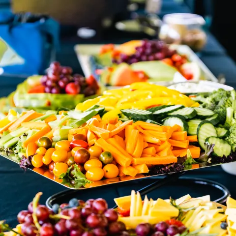 An assortment of fruits, vegetables, and condiments as part of a crudités platter