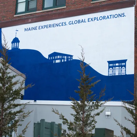 Photo of mural on Decary Hall depicting graphics of UNE's three campuses