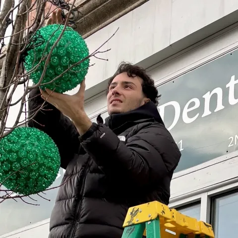UNE students hang lights to provide holiday cheer in downtown Biddeford 