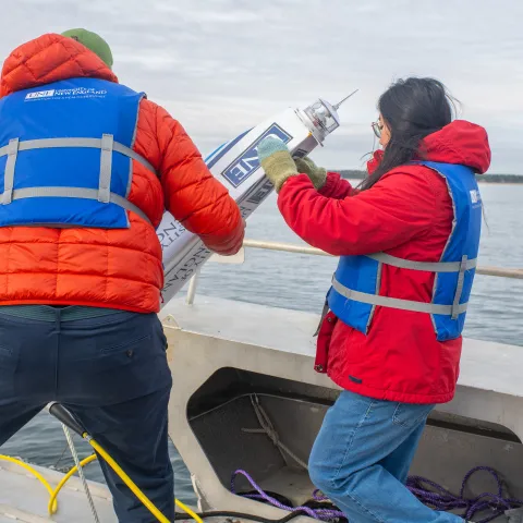 UNE student Jasmin Townsend-Ng (’26) assists Dr. Kochtitzky in lower a buoy