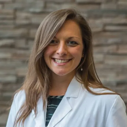 Headshot of Stephanie Podolski against blue backdrop