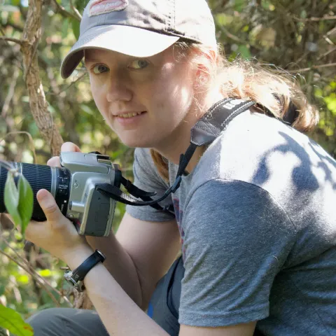 UNE faculty member Maggie Stanton holds a camera in Gombe National Park