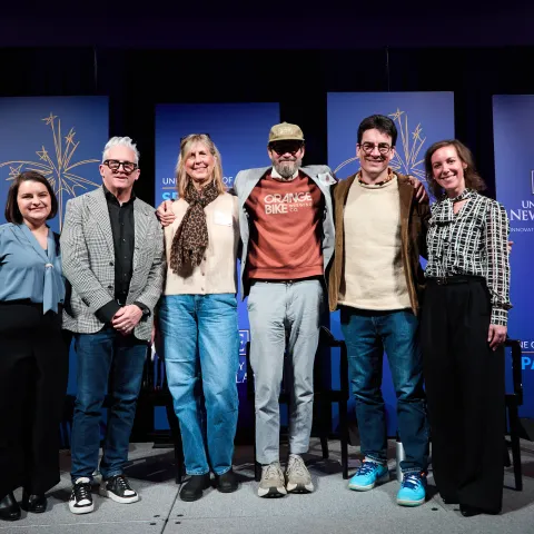 A group of people pose for a photo onstage