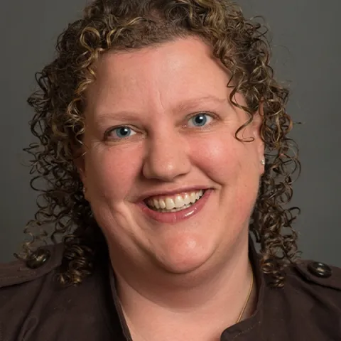 Headshot of Elizabeth Crampsey against blue background