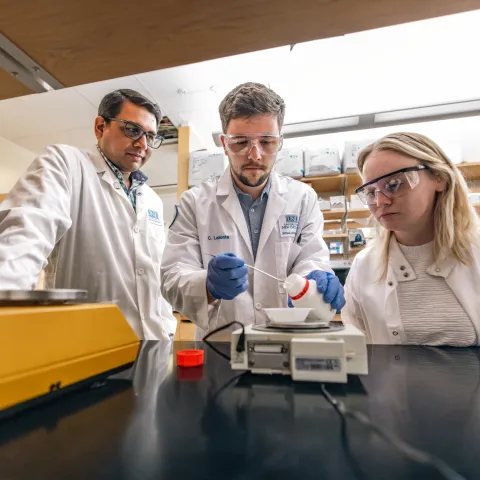 A UNE researcher and students work in a Portland Campus lab