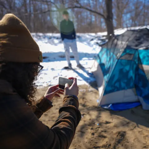 A UNE business student photographs camping gear